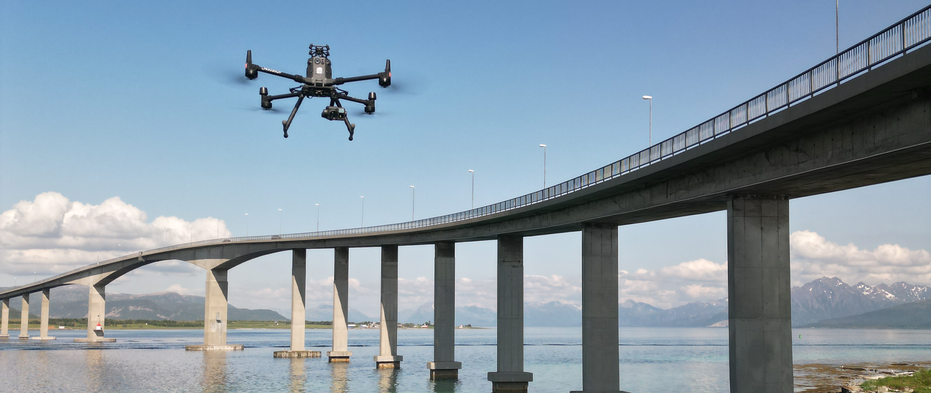 A quadrotor flying alongside a bridge during an inspection.
