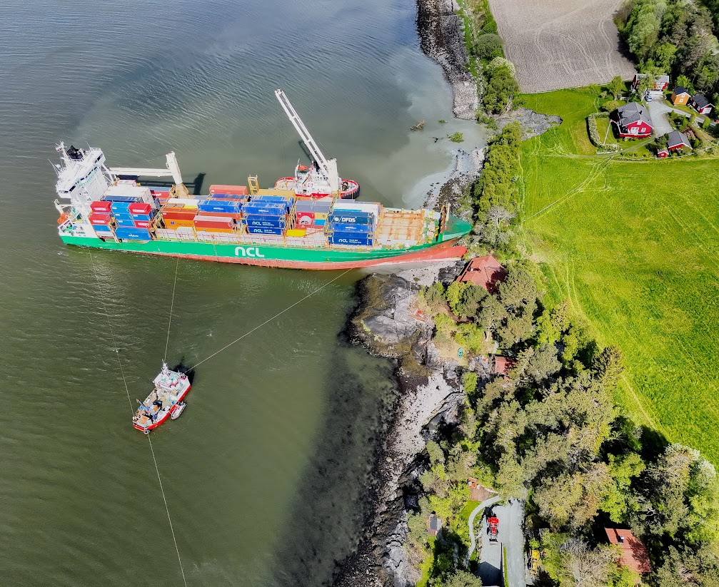 Cargo ship being pulled out by rescue vessels after having struck ground near Bryneset.