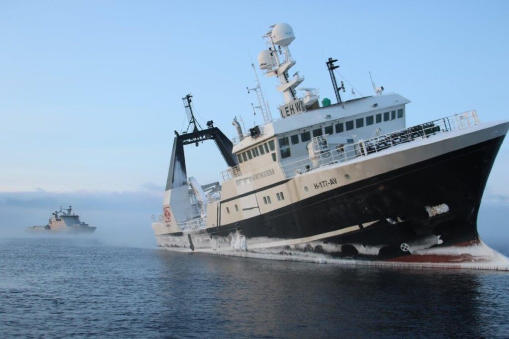 The vessel Northguider being grounded with the Norwegian Coast Guard Vessel KV Svalbard seen in the background.
