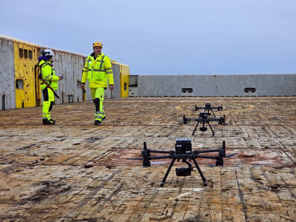 Pilots operating drones from a vessel.